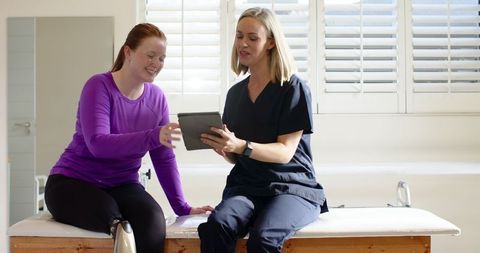 Therapist consulting with woman for prosthetic options using tablet