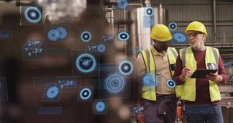 Engineers reviewing ar data on tablet with hud overlays in industrial factory