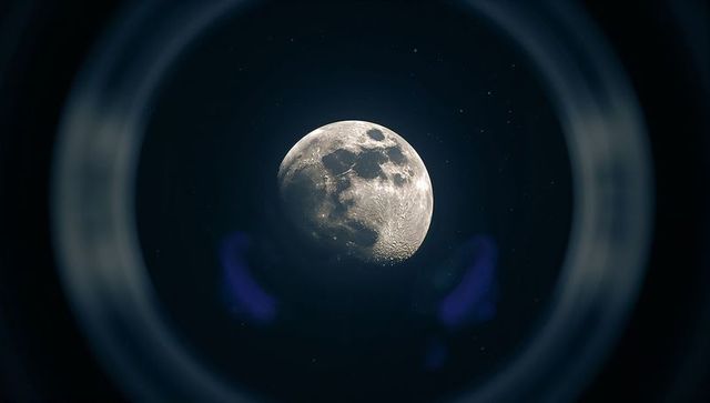 Craters of half moon glimpsed through telescopic lens