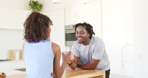 African American Couple Sharing Smoothie at Bright Modern Kitchen Island, Smiling Casually