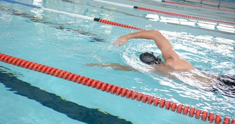 Male swimmer performing freestyle stroke in competitive pool