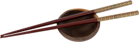 Transparent traditional chopsticks resting on small dark wooden bowl