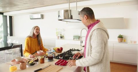 Senior Couple Enjoying Breakfast in Modern Kitchen with French Press