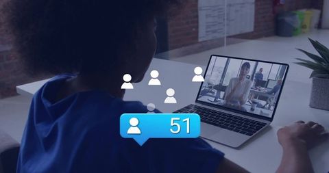 Watching remote team meeting on laptop showing 51 participants notification and coworking