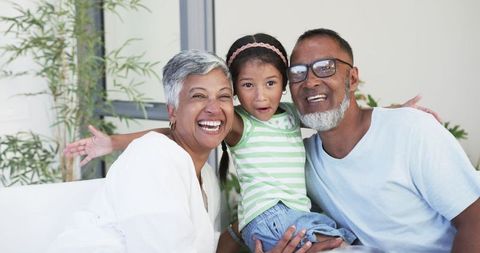 Happy Grandparents Embracing Granddaughter at Home