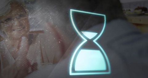 Senior woman activating holographic hourglass timer during digital health reminder
