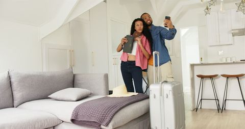 Couple Excited for Vacation Snapping Selfie with Suitcase Packed