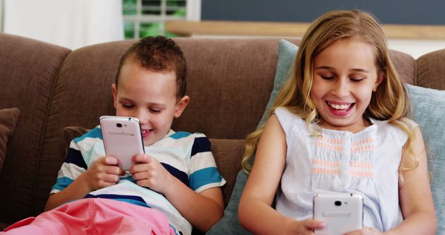 Smiling Children Enjoying Mobile Games on Couch - Download Free Stock Images Pikwizard.com