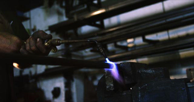 Metalworker using blowtorch on steel rod in industrial workshop - Download Free Stock Images Pikwizard.com