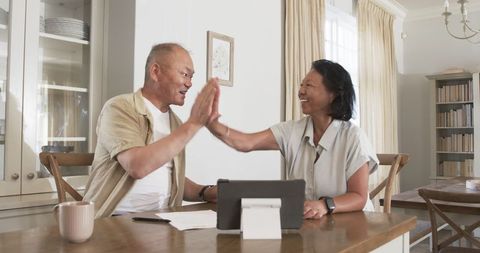 Senior couple engaging with technology provides heartwarming high-five