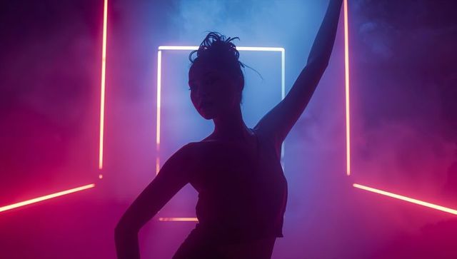 Dynamic contemporary dancer posing with neon lighting