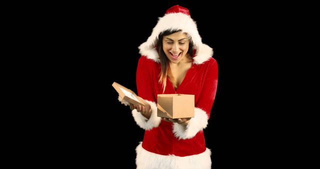 Woman in Santa Outfit Excitedly Opening Gift Against Black Background - Download Free Stock Images Pikwizard.com