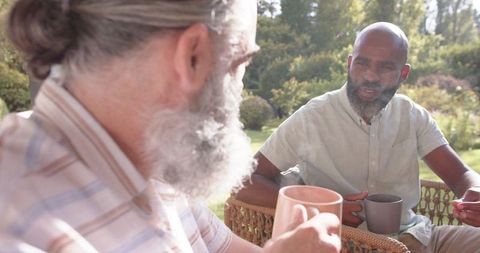 Senior Friends Enjoying Coffee in Sunny Garden