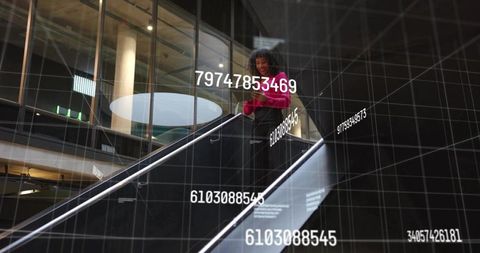 Smiling professional on escalator checking smartphone with digital data grid overlay