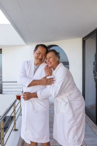 Senior Couple Relaxing on Balcony in Bathrobes