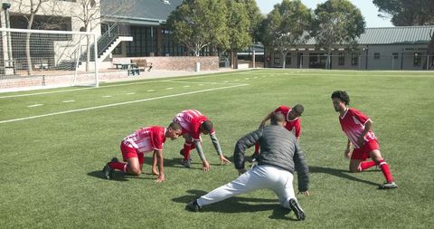 Youth Soccer Team Practicing with Coach in School Field