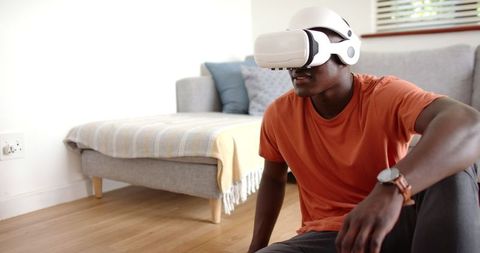 Modern Young Man Experiencing Virtual Reality at Home