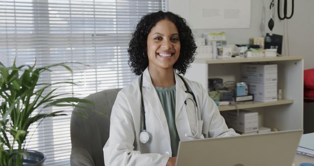 Smiling Female Doctor Working on Laptop in Medical Office - Download Free Stock Images Pikwizard.com