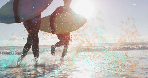 Surfing Enthusiasts Running into Ocean with Surfboards at Sunrise