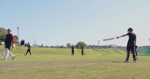 Cricket Players Practicing on Sunny Day Outdoors
