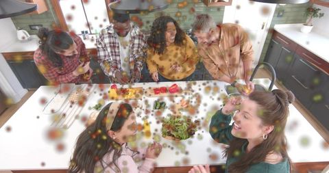 Friends cooking together at kitchen island preparing fresh meal with confetti overlay