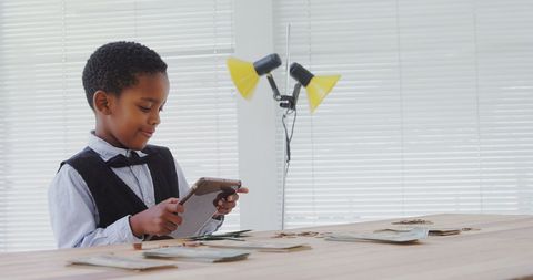 Young businessman using tablet surrounded by money