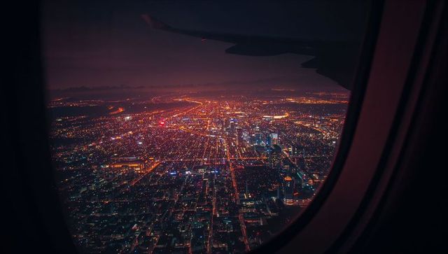 Cityscape Night View from Plane Window with Illuminated Skyline