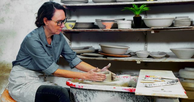 Woman creating pottery on wheel in studio - Download Free Stock Images Pikwizard.com