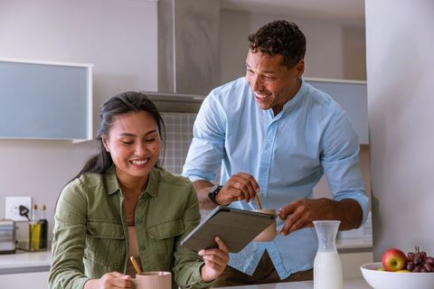 Couple Enjoying Morning Coffee and Exploring Tablet in Kitchen