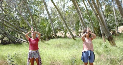 Women Practicing Yoga Outdoors in Lush Natural Setting
