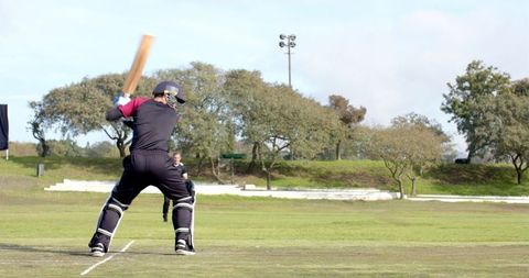 Batsman swinging cricket bat during outdoor match
