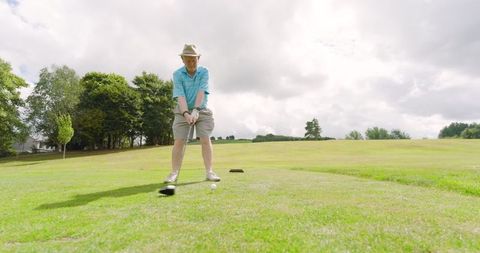 Senior man preparing golf swing on sunny course day
