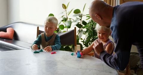 Father engaging children in creative clay activities at home