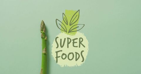 Fresh Asparagus and Super Foods Concept on Green Background
