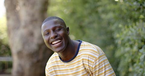 Young African American Man Laughing Outdoors in Sunlight