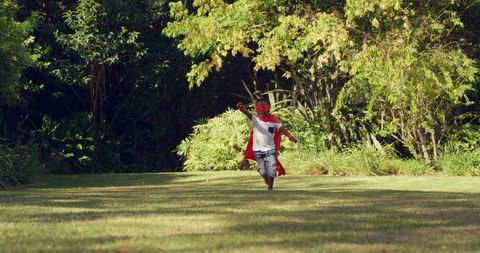 Child in superhero costume running joyfully in lush park - Download Free Stock Images Pikwizard.com