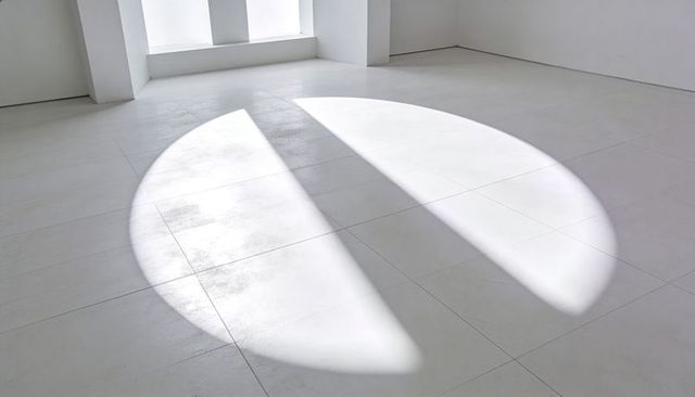 Circular Sunlight Slicing Through Window Columns on Minimal White Tiled Floor