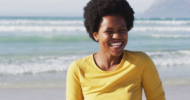 Portrait of happy african american woman on sunny beach. healthy and active time beach holiday.