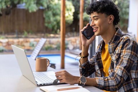 Young Man Relaxing and Working on Laptop Outdoors
