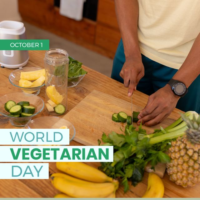 This image shows an African American man slicing cucumbers on a wooden cutting board in a modern kitchen, surrounded by various fresh fruits and vegetables. Perfect for promoting healthy eating habits, World Vegetarian Day, or wellness programs. Can be used in blogs, health magazine articles, social media posts on nutrition, or cookbooks.