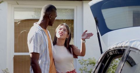 Diverse Couple Preparing for Weekend Getaway with Car