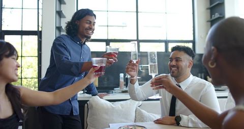 Diverse friends toasting with wine and champagne in bright modern kitchen celebration