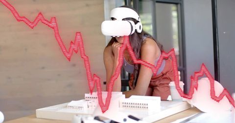 Architect Engaged in VR Design with Declining Graph Overlay