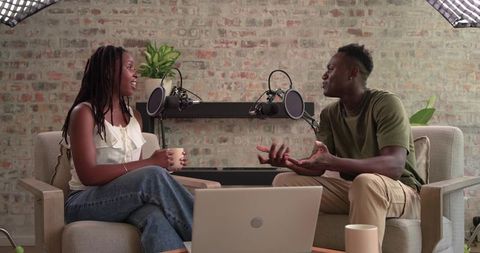 African american co-hosts recording relaxed conversational podcast in cozy studio