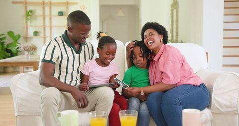 Happy Family Bonding Over Ultrasound Photos on Couch