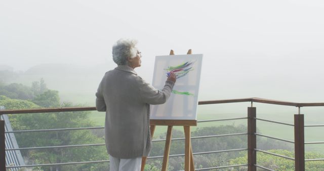 Senior Woman Painting on Outdoor Terrace in Scenic Foggy Morning - Download Free Stock Images Pikwizard.com