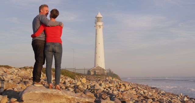 Couple Embracing by Ocean Side Lighthouse During Sunset - Download Free Stock Images Pikwizard.com