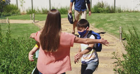 Children Hugging Mother in Garden After School