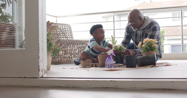 Father and son enjoying a gardening activity on a sunny balcony. Perfect for themes of family bonding, parent-child relationships, and outdoor activities. Excellent for educational content, gardening advertisements, and lifestyle blogs highlighting family moments and quality time spent together.