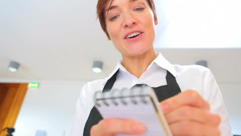 Smiling Waitress Taking Order in Restaurant Setting